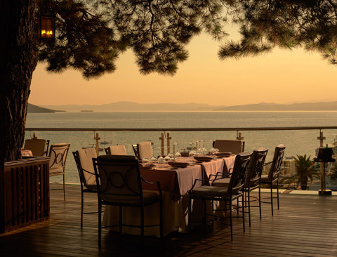 Eagles Resort Chalkidiki Kamares Restaurant tables under the pine trees, at the sunset